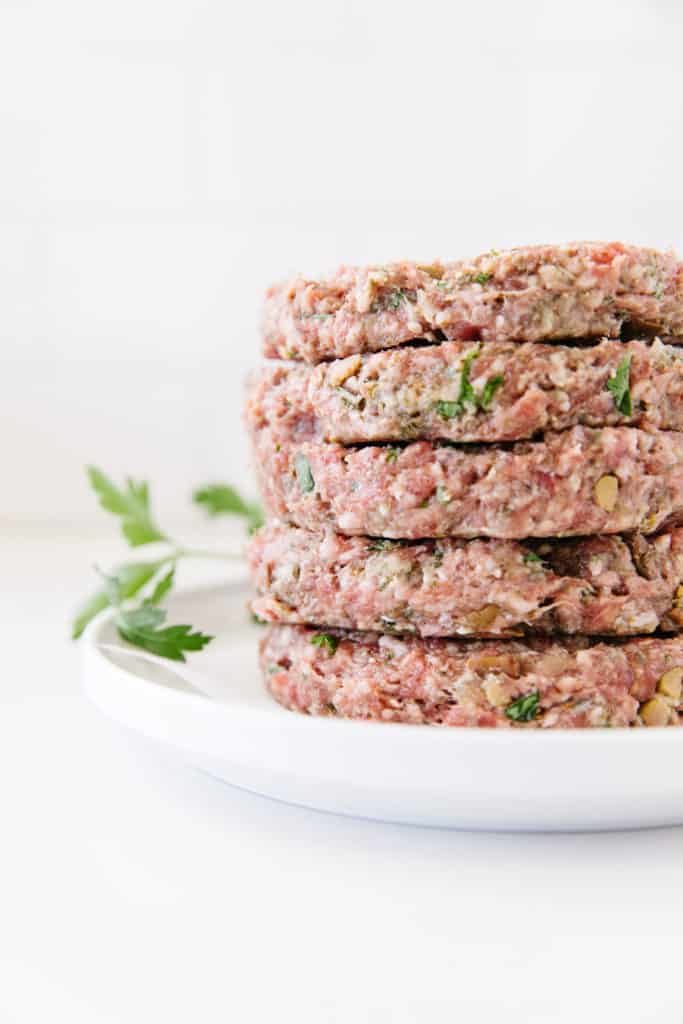 mediterranean Lamb burger patties stacked high before grilling  